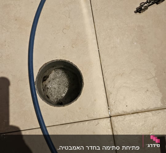 צינור כחול ליד פתח ניקוז ברצפה